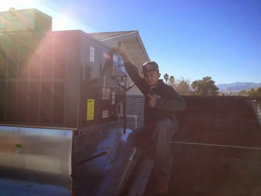 HVAC technician performing Air Duct Repair on a rooftop unit in Hopkinsville